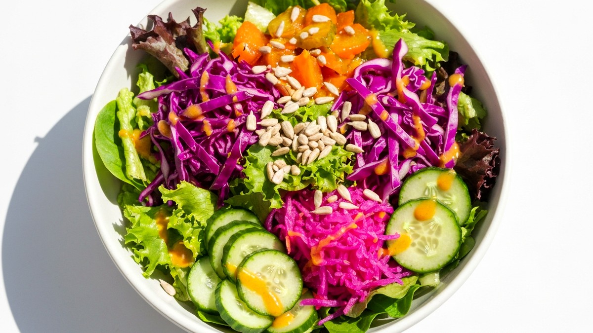 Vibrant gut health salad with kimchi, fermented vegetables, mixed greens, seeds, and miso dressing