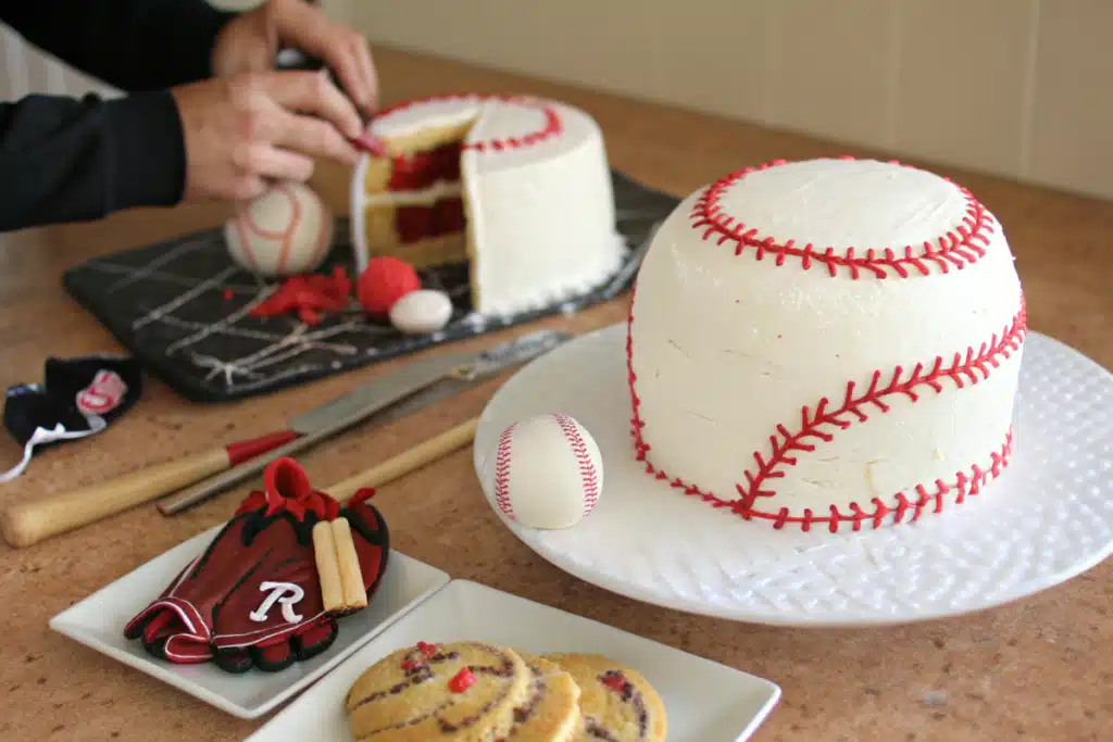 A finished baseball cake with fondant decorations like bats and gloves, made with Hy-Vee Cookies & Cream Mix.